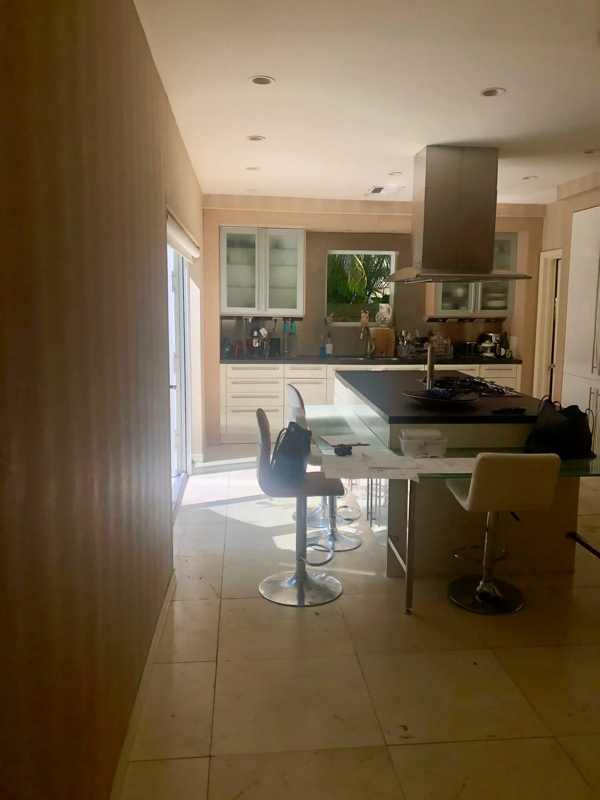 Miami kitchen before the renovation: dated cabinetry and a dark island under a steel hood
