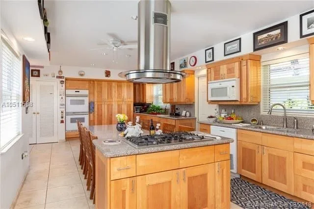 Miami kitchen before: honey oak cabinets, granite counters and an island cooktop