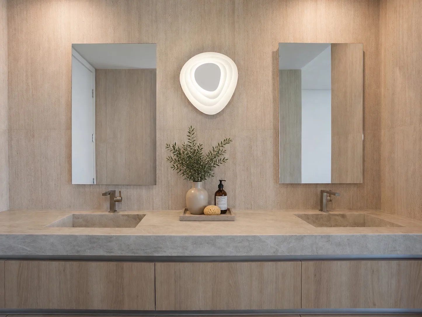 Marquis 3301 primary bathroom by DALOP Design: a travertine double vanity with twin mirrors and a sculptural wall light