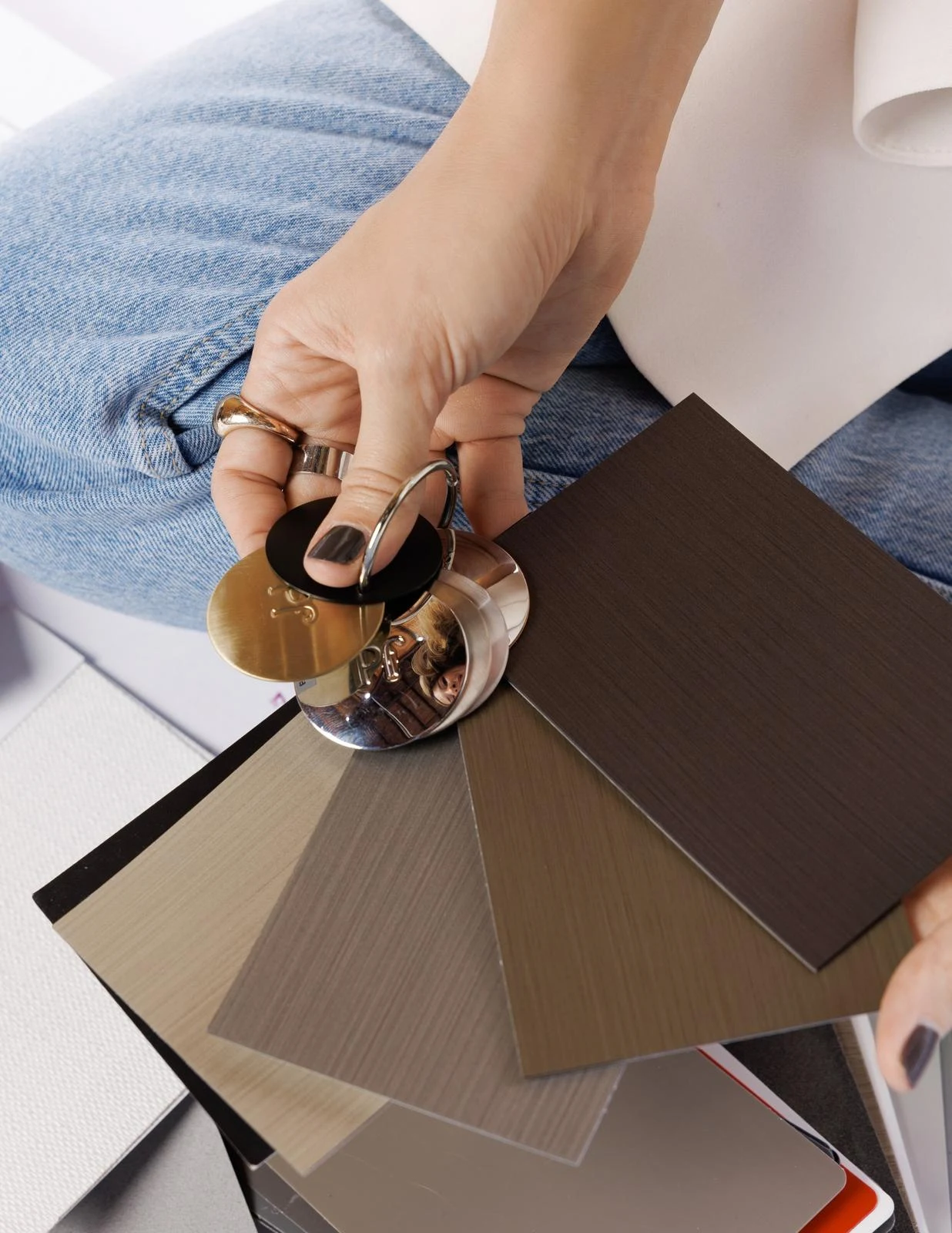 Daniela Lopez holding a fan of wood and laminate finish samples during a selections meeting
